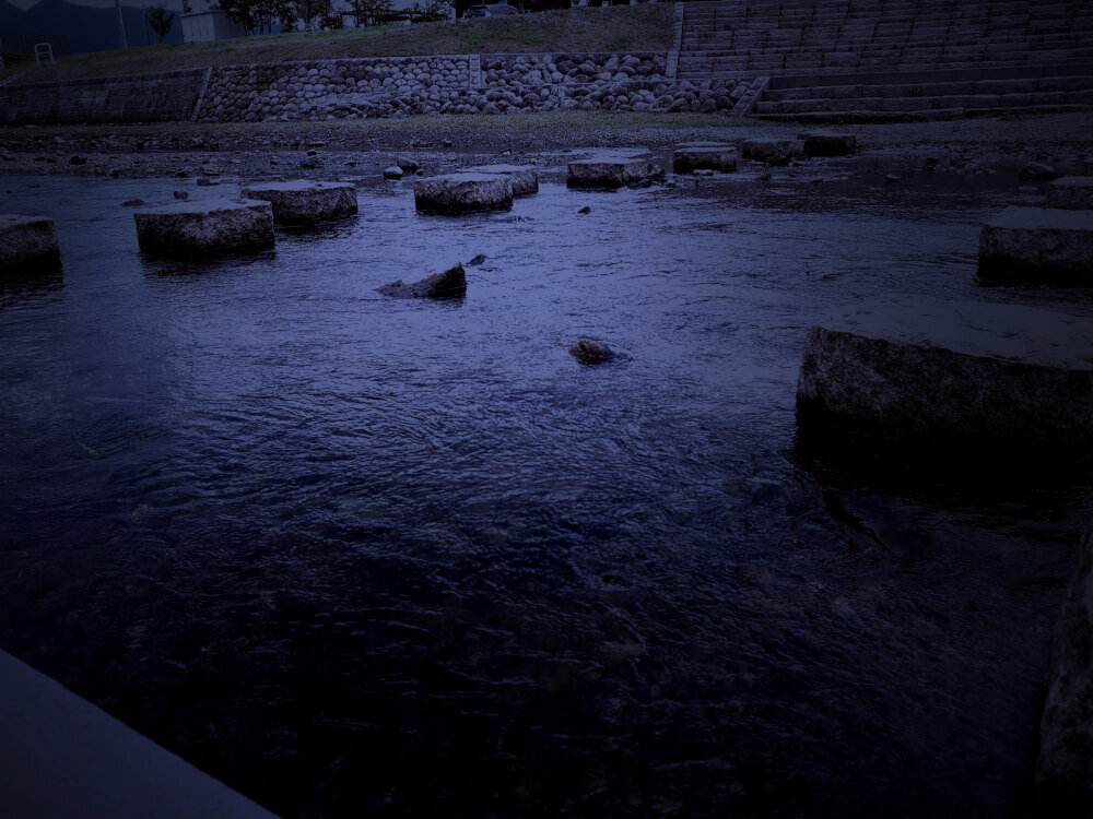 薄暗い川辺の飛び石のイメージ