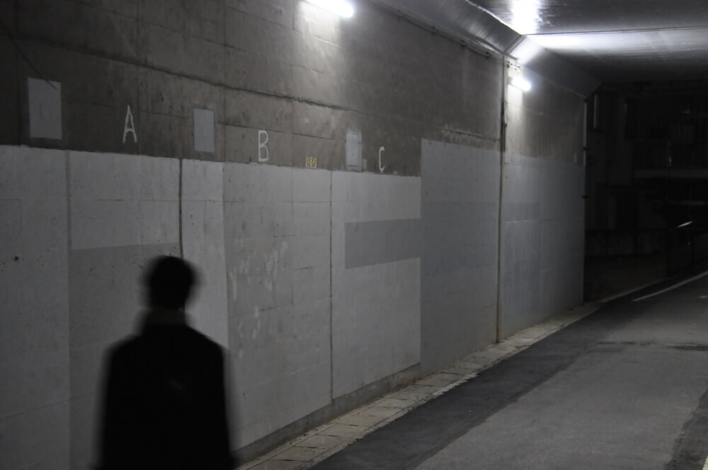 高架下トンネルを歩く人の写真